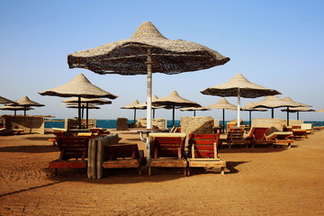 Rusty textured beach umbrellas on the empty beach in the morning