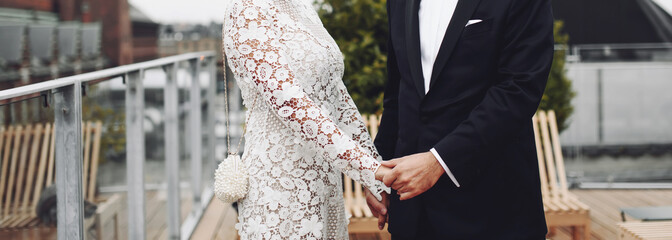 young wedding couple holding hands, groom and bride