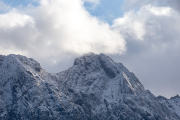 People on Giewont Mountain in polish Tatra Mountains covered with snow in autumn.