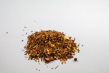 piled orange herbal tea seeds from top view with an isolated background