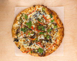 Pizza on a wooden table close-up. Freshly baked pizza on a wooden surface. Top View.