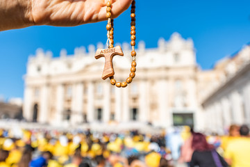 Macro closeup of wooden handmade Italian cross Catholic Assisi rosary with bokeh background of...
