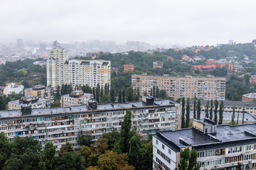 Fototapeta premium Kijów, Ukraina panoramę miasta Kijowa przez Vokzalna stacja metra obszar podczas ponurego, smutnego, ciemnego, deszczowego, pochmurnego i pochmurnego dnia, budynki mieszkalne w stylu sowieckim, deszcz