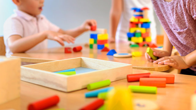 Children playing with colorful wooden didactic toys at kindergarten