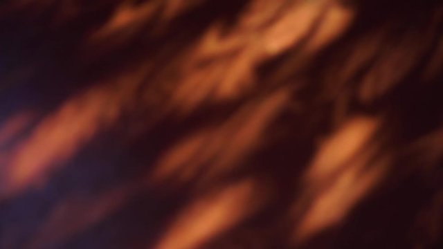 Brown dark background of messy shadows from sunlight through window with spots falling on wooden floor in dark morning room. Real time 4k video footage.