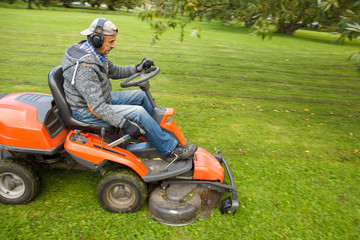 lawn mower tractor working in the town park
