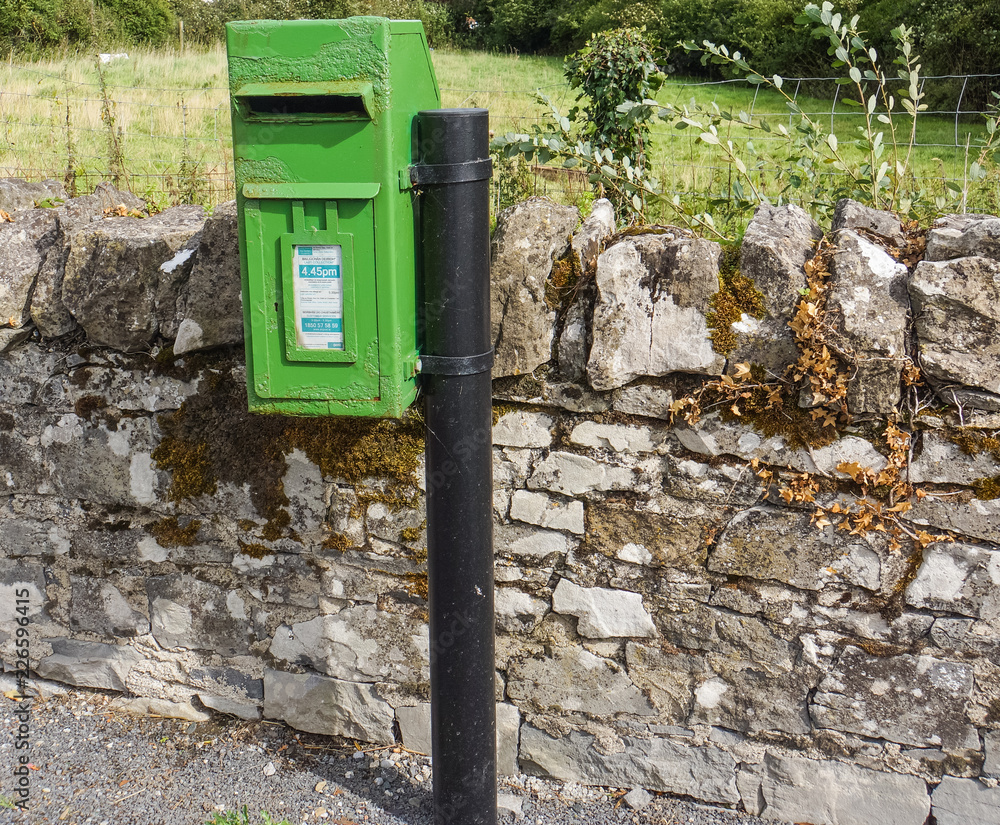 Wall mural bright green rural post office mail box  on Irish country road 