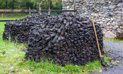 Fototapeta na wymiar pile of sod or turf cut from the bog for burning with cutting tool 