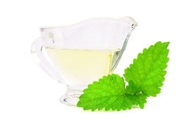 Lemon Balm (Melissa) Essential Oil in a Glass Container. Also Melissa Officinalis, Common Balm Mint. Isolated on White Background.
