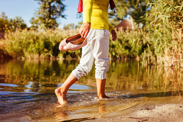 Middle-aged woman walking on river bank on autumn day. Senior lady having fun in the forest enjoying nature. Closeup