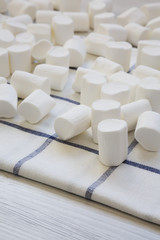 Sweet white marshmallows on cloth, side view. Close-up.