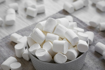 Fototapeta na wymiar Sweet white marshmallows in a bowl, side view. Close-up.