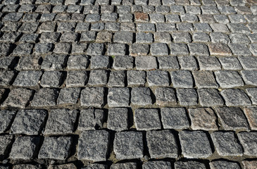 Stone road close up. Old pavement of granite. Grey cobblestone sidewalk. Mock up or vintage grunge texture.