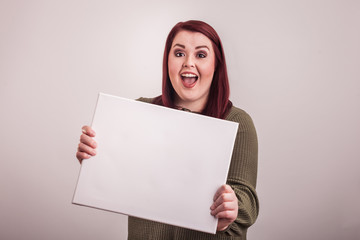 Happy smiling young woman holding blank board 