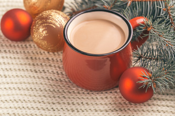 Bright red cup of hot cocoa and christmas tree