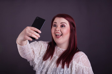 Young plus size woman taking selfie smiling with mobile phone 