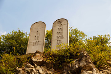 Ten Commandments List. Stone tablets on a rocky hill with carved 10 commandments.