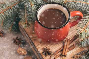 Red cup of hot cocoa on wooden cutting board