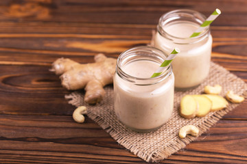 Obraz na płótnie Canvas Banana and almond smoothie with ginger in glass jars