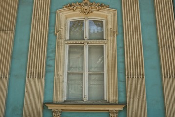 large retro window on a blue gray building wall