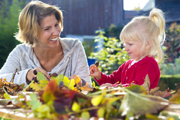 Deutschland, Bayern, Allgäu, Herbstimmung, Frau und Mädchen basteln mit Kastanien und...