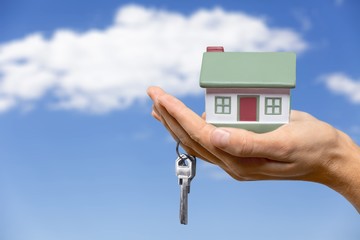 Naklejka premium Businessman Holding House Model and Keys
