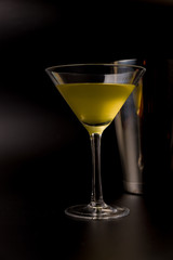 yellow cocktail with shaker on black background