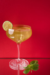 yellow cocktail with mint with red background