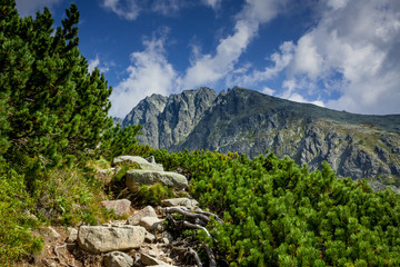 Stone path between mountain pains and rocks with a blue sky on the background