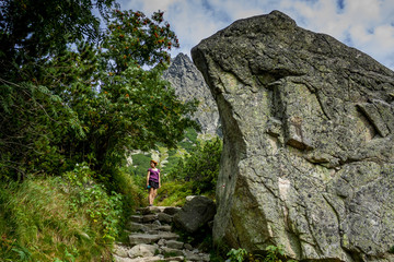 Obraz premium Young woman standing on path near big stone in High Tatras