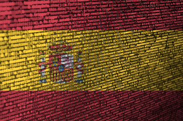 Spain flag  is depicted on the screen with the program code. The concept of modern technology and...