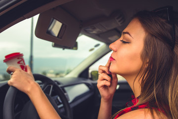 Obraz na płótnie Canvas Woman fixing her lipstick in a car