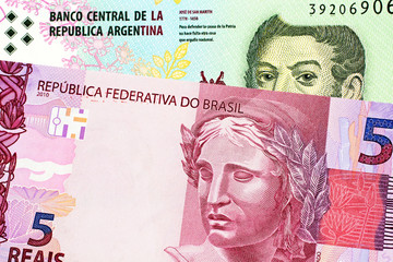 A macro image of a pink Brazilian five reais note with an Argentinian five peso bill