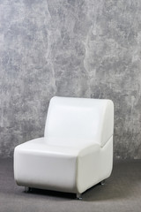 Leather office chair in empty room with gray texture wall background. Business interior background. International Exhibition furniture elements in large warehouse interior.