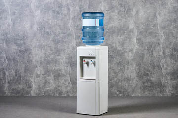 White water cooler gallon in office against gray textured wall background. International Exhibition...