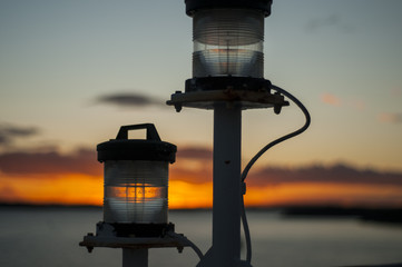 Signal lights on board of the ship at sunset. Sunlight passing through the lamps.