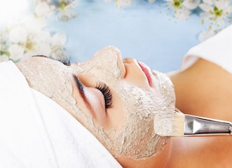 Young woman with facial mask at spa