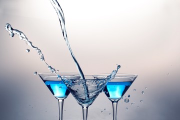 Martini Being Poured From Afar And Martini Drinks in Background