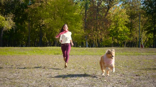 girl running with collie dog at autumn park