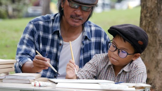Senior Man training Boy about artist skill at park. People with student, education, homework concept. 4k Resolution.