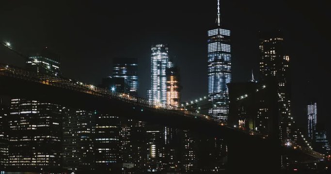 Amazing night Brooklyn Bridge timelapse, New York. Low angle. Highrise illumination lights and traffic passing by. USA