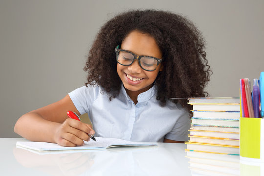 schoolgirl with glasses doing homework