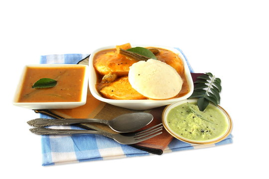 Popular South indian breakfast food Idly sambar or Idli rice and lentils steamed cakes with spicy soup Sambhar and green coconut chutney 