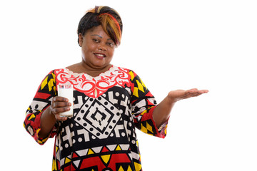 Studio shot of happy fat black African woman smiling while holdi