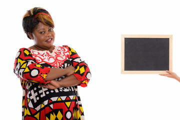 Studio shot of happy fat black African woman smiling with arms c