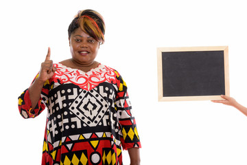 Studio shot of happy fat black African woman smiling while point