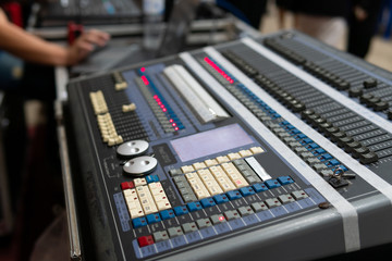 Close up of the rows of knobs and sliders on an analogue mixing console