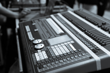 Close up of the rows of knobs and sliders on an analogue mixing console