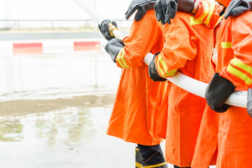 Firefighter using extinguisher and water from hose for fire fighting, Firefighter spraying high...