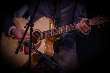 Fototapeta na wymiar Closeup of someone playing an acoustic guitar